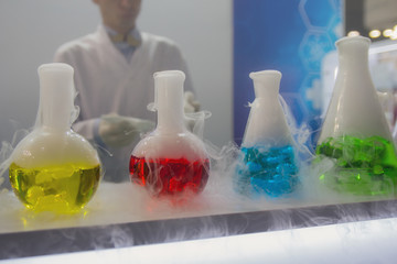 Laboratory glassware with solutions of different colors on table. Science