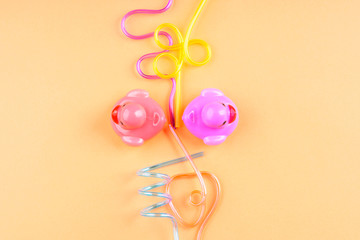Party cocktail straws and rubber ducks on orange. Flat lay on orange pink background. Copy space