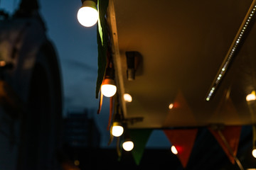 Vintage antique hanging light bulbs at a street food market.  Food trucks, holidays and business...