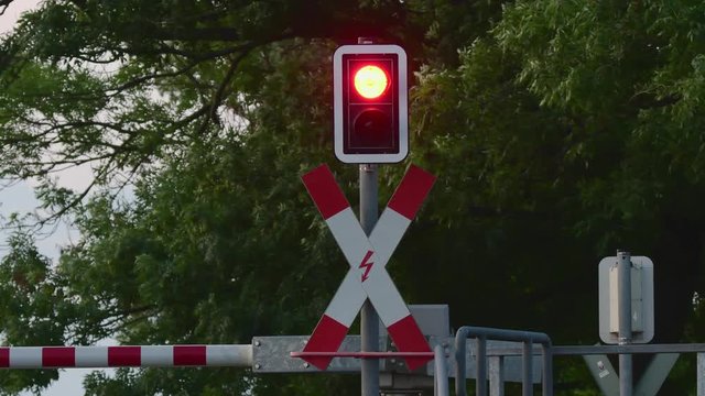 Andreaskreuz am Bahn&uuml;bergang mit Vorbeifahrt eines Reisezuges