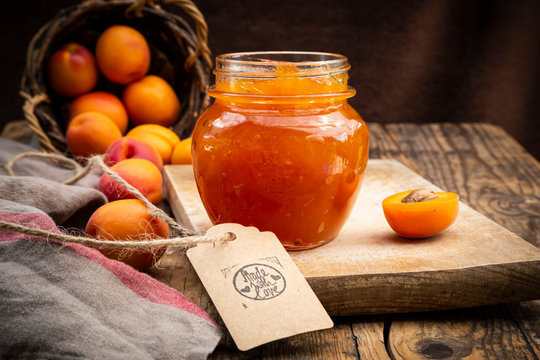 Apricot jam and apricots, sign 'made with love' on dark wood