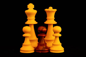 White King and Queen with mixed color pawns family as interracial adoption concept.Standard chess wooden pieces on black background