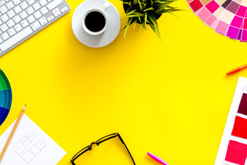 Designer work space with pallet, glasses, keyboard and coffee on yellow background top view mockup