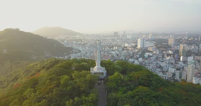 Jesus Christ`s Statue in Vung Tau, Vietam, Asia, South-East Asia, 4k drone footage. Sunset and many buildings visible