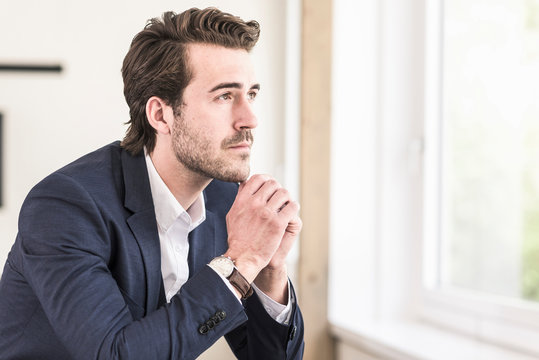 Pensive businessman sitting at the window