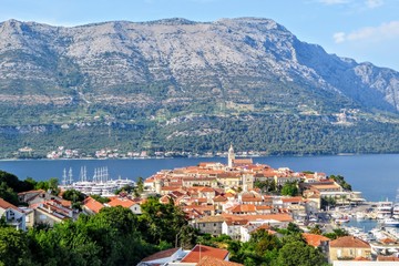 A view from afar looking down through the trees from a lookout of the beautiful ancient Croatian town of Korcula, on Korcula Island in the Adriatic sea off the coast of Croatia