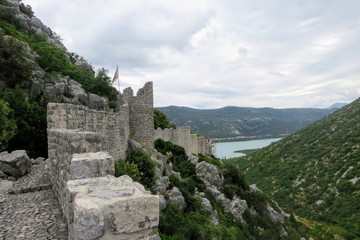 A view high up along the rocky fortress walls and pathways of the walls of Ston, surrounding Ston, Croatia.  The wall is an ancient defensive wall made of limestone