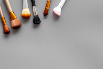 Instruments for make up with brushes on gray background top view mock up