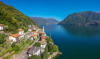 Aerial view landscape on beatiful Lake Como in Lombardy, Italy. Scenic small town with traditional houses and clear blue water. Summer tourist vacation on rich resort with nice harbour