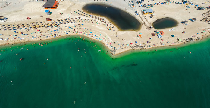 Panorama of sea shore in Berdyansk, South Ukraine, Europe. Resort city with nice sand beach and clear blue sea. Famous travel destination, ideal place for comfort vacation on Azov Sea. Drone photo