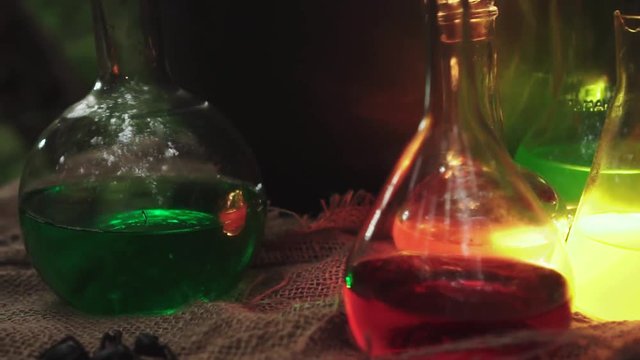 Shooting Halloween party decorations. Banks, flasks, glass, glasses with colored potion that glows in the dark. Ingredients for sorcerers and magic potions are on the table.