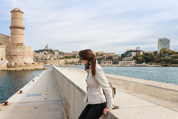 Tourist woman in French historical city Marseille and Mediterranean sea coast. Marseille is the biggest port in France, South Europe. Famous large city and tourist destionation.