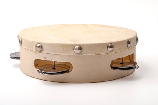 Percussion instruments and traditional music concept theme with close up on an wooden tambourine isolated on white background with a clip path cut out