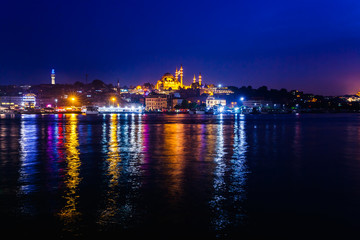 Fototapeta premium Night view of Istanbul. Panorama cityscape of famous tourist destination Golden Horn bay part of Bosphorus strait. Travel illuminated landscape Bosporus, Turkey, Europe and Asia.
