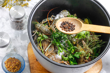 Fresh crayfish in a bowl of the multicooker with salt and black peppercorns - ingredients for cooking boiled crayfish in a multicooker. Step 4.