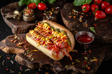 Hot dog with ketchup and mustard  for take away or food delivery on wooden background.