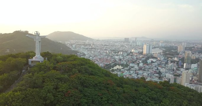 Jesus Christ`s Statue in Vung Tau, Vietam, Asia, South-East Asia, 4k drone footage. Sunset and many buildings visible