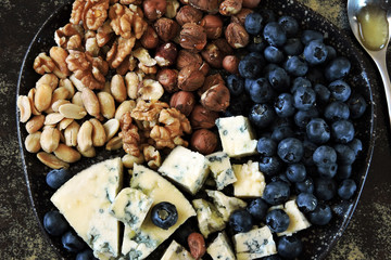 Plate with blue cheese, blueberries and nuts. Keto diet. Keto snack.