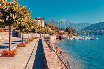 Panorama landscape on beatiful Lake Como in Tremezzina, Lombardy, Italy. Scenic small town with traditional houses and clear blue water. Summer tourist vacation on rich resort with nice harbour