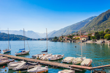 Fototapeta na wymiar Panorama landscape on beatiful Lake Como in Tremezzina, Lombardy, Italy. Scenic small town with traditional houses and clear blue water. Summer tourist vacation on rich resort with nice harbour