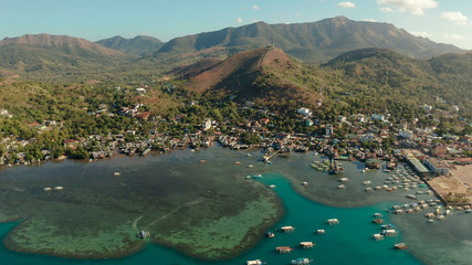 Fototapeta na wymiar sea port, pier, cityscape Coron town with boats on Busuanga island, Philippines, Palawan. Coron city with slums and poor district. Seascape with mountains.