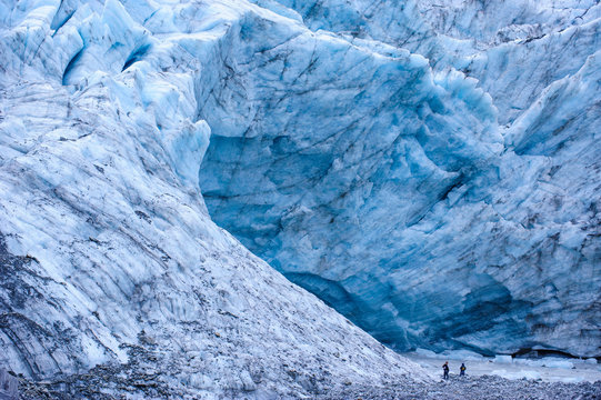 Tourists hiking to the giant glacial outflow of Fox Glacier, South Island, New Zealand
