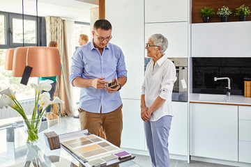 Man and mature woman in a kitchen retail store examining material samples