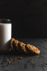 Cookies and a glass of milk with a dark textured background