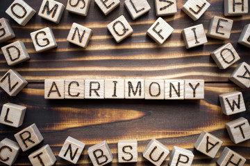 acrimony wooden cubes with letters, bitter full of anger concept, around the cubes random letters, top view on wooden background