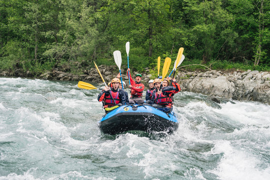 Group of people rafting in rubber dinghy on a river