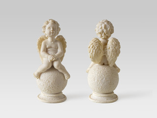 Small angels sitting on a round stones