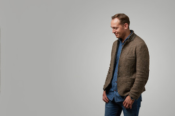 A man wearing a shirt and jacket on a gray background, shows the emotions of happiness. Concept banner for advertising, copy space, gray background.