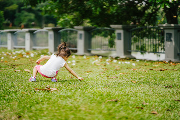 Asian toddler girl running in the park at the spring or summer day.