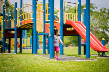 Fototapeta na wymiar Adorable little 1-2 year old Asian toddler girl having fun on playground.
