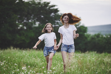 Obraz premium mother and daughter running in the field