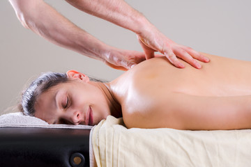 Fototapeta na wymiar Man massaging a young woman in the salon