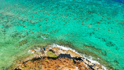 aerial view water surface with waves and coast tropical island. Lagoon with turquoise water. top view blue water