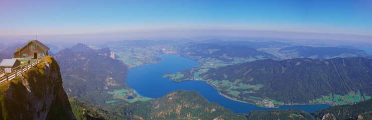 Fototapeta na wymiar Aerial panoramic view of Austrian Alps nature, Mondsee lake from Schafberg peak near st. Wolfgang, Austria, Salzburg. Picturesque mountain lake in the summer morning landscape, large panorama banner.