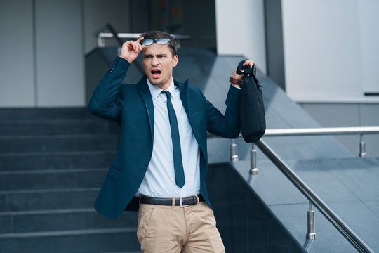 businessman with binoculars in front of building