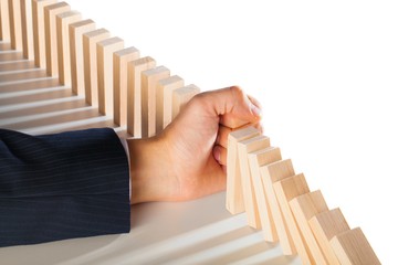 Businessman Hand Stop Falling Domino Pieces