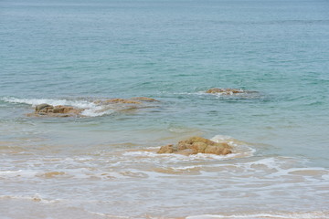 Beach view on the island with white waves and fishing boats	