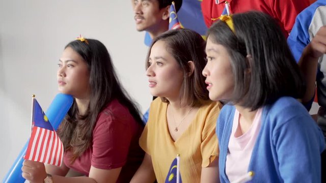 malay group of people holding malaysia flag celebrating independence day