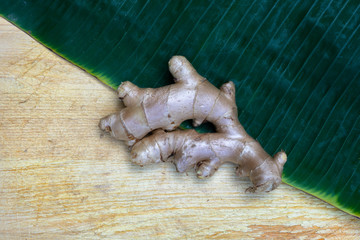 Fresh ginger on wooden chopping board, herb ingredient concept