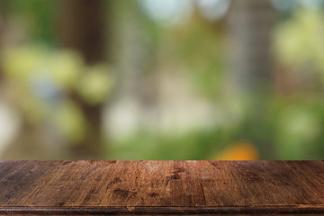 Empty dark wooden table in front of abstract blurred bokeh background of restaurant . can be used for display or montage your products.Mock up for space.