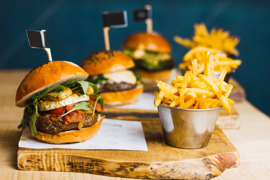 Juicy delicious burger and fried potato on table