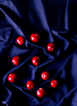 From above bunch of ripe sweet plums placed on wrinkled blue fabric