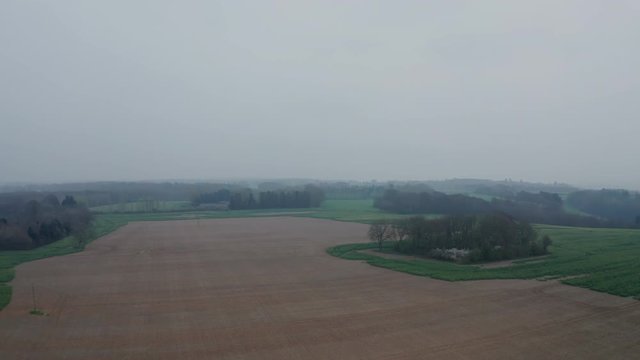 Aerial view of a plowed field on a misty spring morning.