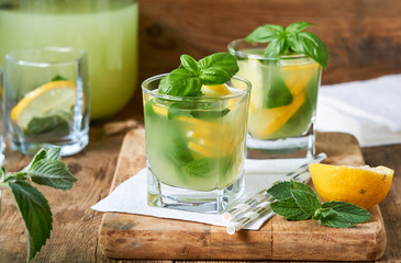 Citrus lemonade with basil and mint on a wooden background