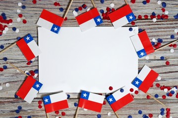 September 18, happy independence day of Chile. memorial day for independence. the concept of patriotism. mini flags and confetti on white wooden background with white paper sheets