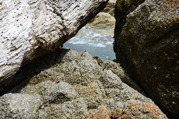 The sand and the waves hit the rocks at the beach of the island.